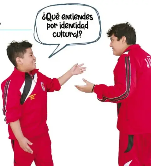 Dos estudiantes con uniforme rojo dialogando; uno de ellos tiene un globo de diálogo que dice: '¿Qué entiendes por identidad cultural?'.