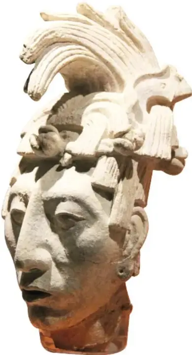 Fotografía del esqueleto de la Reina Roja con máscara de malaquita y un gran pectoral de conchas y piedras colocados sobre el cuerpo en su sarcófago.