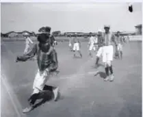 Fotografía histórica de personas practicando fútbol en un espacio abierto.