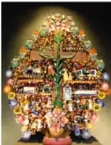 Fotografía de un Árbol de la vida: escultura colorida que representa el origen de la vida con elementos de la cultura occidental; al pie aparecen Eva y Adán.