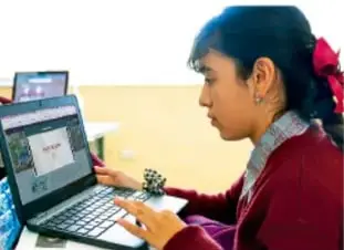 Fotografía de una estudiante de secundaria usando una computadora portátil, ilustrando el uso de materiales digitales.