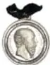 Fotografía del anverso de una medalla conmemorativa de Maximiliano con ficha de museografía.