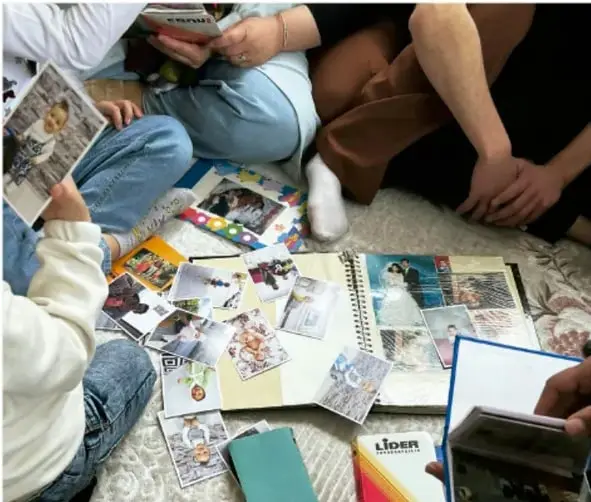 Mano sosteniendo un teléfono celular que muestra una galería de fotografías digitales (comidas, animales, personas y lugares).