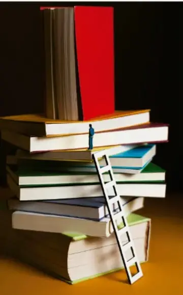 Fotografía de una pila de libros con una escalera apoyada y una figura humana pequeña subiendo, metáfora del aprendizaje.