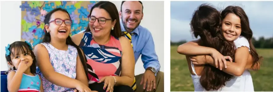 Fotografía de una familia (padres y dos hijas) riendo juntas frente a una pared con decoración de flores de colores, transmitiendo convivencia y armonía familiar.