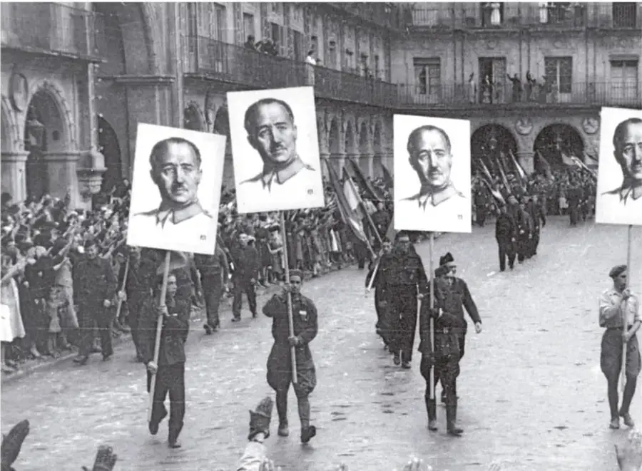 Fotografía de una marcha con personas sosteniendo retratos de Francisco Franco en un entorno urbano.