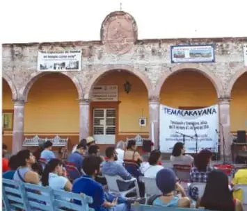 Personas reunidas en un espacio público con un cartel que dice 'TLAXCALAYA'.
