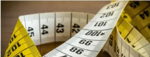 Cinta métrica amarilla enrollada mostrando números 44, 43, 42, 101, 100, 99, 98.