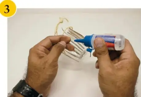 Manos sosteniendo un bebedero para aves hecho con material reutilizado y aplicando pegamento.