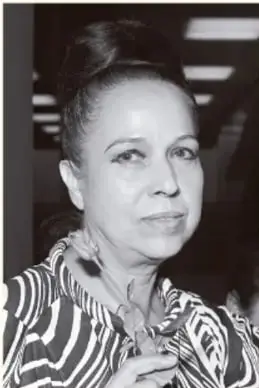 Retrato en blanco y negro de una mujer con blusa de encaje oscuro y aretes grandes.