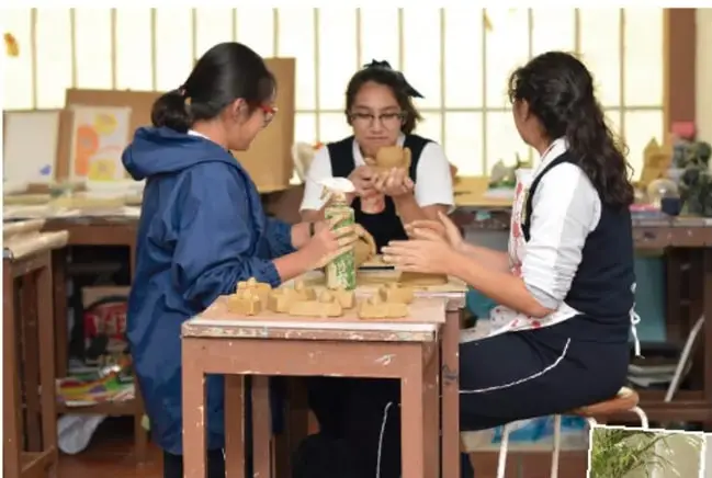 Tres estudiantes trabajando con piezas de madera o modelado en un taller escolar.