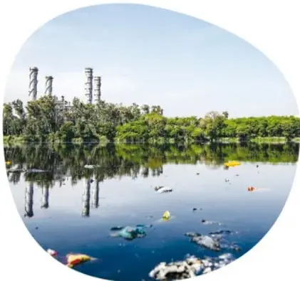 Lago o río con basura flotante frente a una industria con chimeneas, ilustrando desechos industriales.