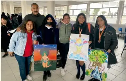 Fotografía de un grupo de estudiantes sosteniendo carteles con dibujos, en un espacio escolar. Pie de foto: Gimenna Schiaffini Rosales, PUEBLA.