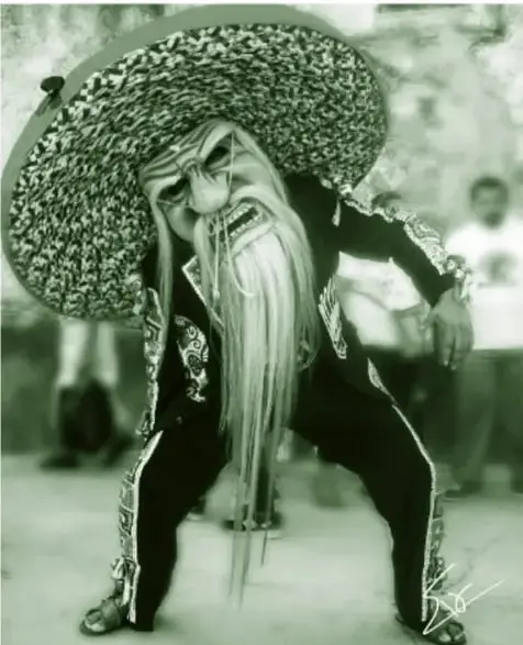 Fotografía de un bailarín de la danza de los tecuanes con máscara de viejo de barba blanca larga y un sombrero de ala extremadamente ancha.