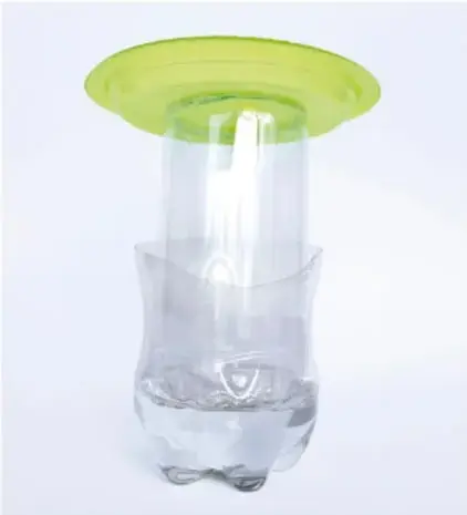 Montaje completo: botella de 2 l con agua, dentro de ella las botellas unidas de 1,5 l, y en la parte superior un plato verde que sirve de base para colocar los objetos a pesar.