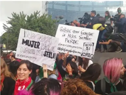 Fotografía de una marcha con personas sosteniendo carteles con consignas como 'Ni una menos', 'Mujer que no se calla', 'La mujer siempre pierde' y 'No más violencia'.
