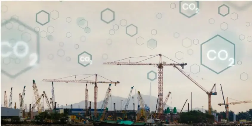 Sitio de construcción con grúas y hexágonos translúcidos representando moléculas de CO₂ flotando en el aire, con humos de maquinaria.