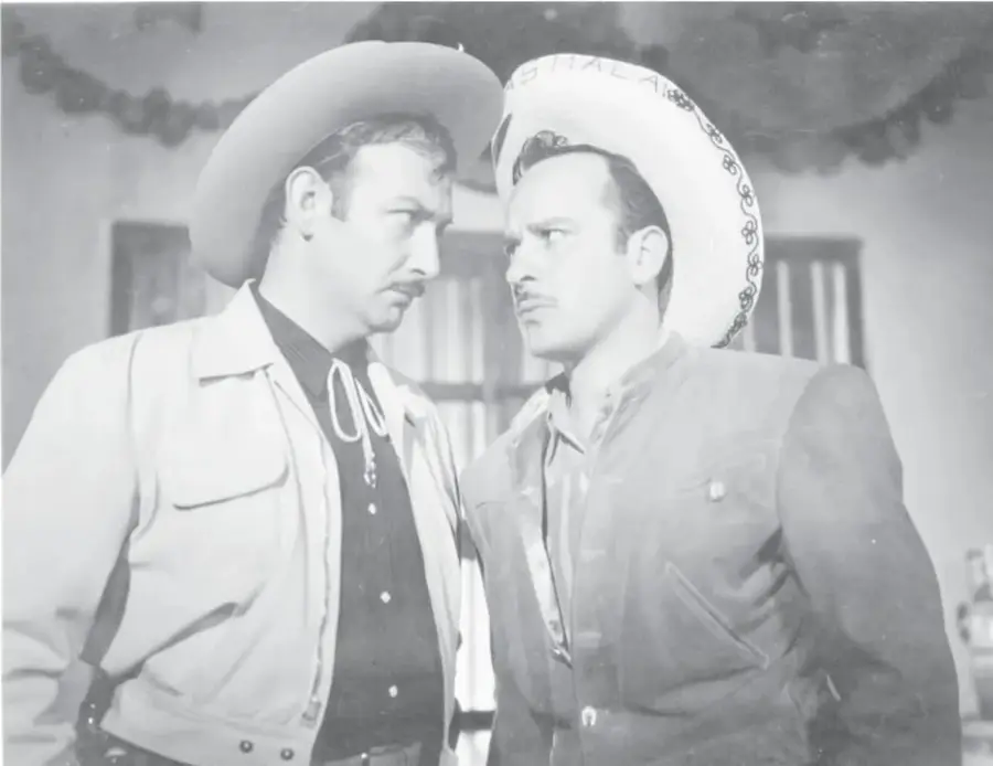Fotografía en blanco y negro de dos hombres con sombrero charro; el de la izquierda es Pedro Infante, con bigote, chaleco y camisa oscura; el de la derecha usa sombrero blanco bordado y chaleco sobre camisa clara.