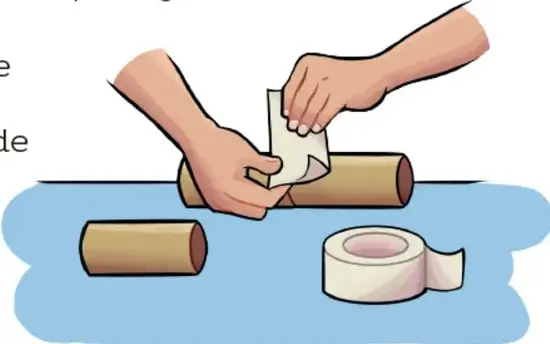 Materiales sobre la mesa: cuatro tubos de cartón, palillos de madera, un punzón de mango rojo, palillos en un vaso, cinta adhesiva, tijeras, un platito con arroz y una hoja de papel.