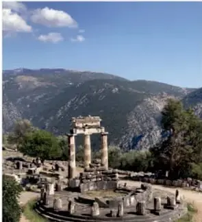 Fotografía de las ruinas del Oráculo de Delfos, en la antigua Grecia, con montañas al fondo.