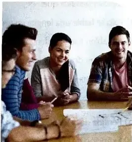 Grupo de jóvenes reunidos alrededor de una mesa, relacionado con la comunicación y el trabajo compartido.