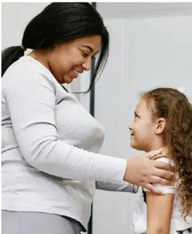 Fotografía de una mujer adulta abrazando con ternura a una niña pequeña, simbolizando protección y confianza en la red de seguridad personal.