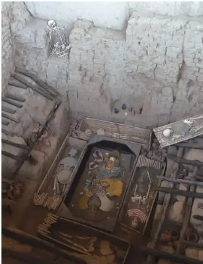 Interior de una tumba moche con restos óseos y ajuares, probablemente la del Señor de Sipán, con ofrendas y estructura de entierro.