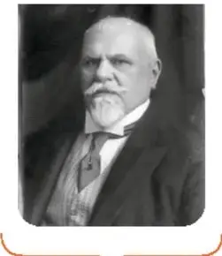 Retrato en blanco y negro de Justo Sierra, hombre mayor con barba blanca, traje y corbata.