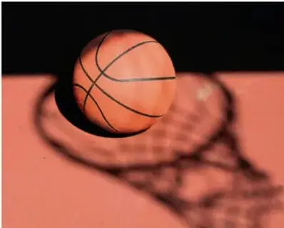 Pelota de baloncesto sobre una superficie iluminada que proyecta su sombra: ejemplo de objeto opaco.