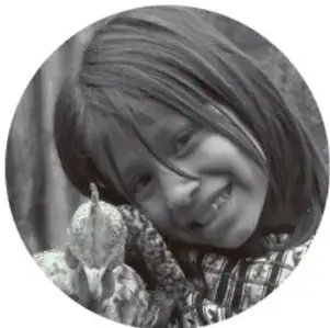 Fotografía circular de una niña sonriente junto a elotes.