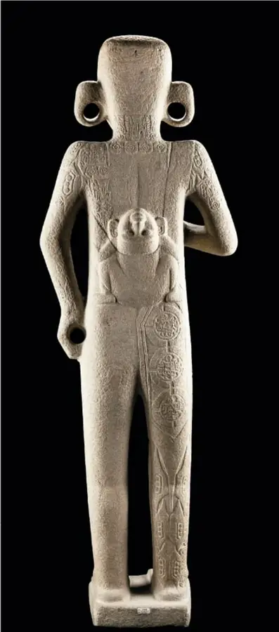 Escultura de piedra El adolescente huasteco, figura humana desnuda con incisiones (escaras) y motivos tatuados en torso y piernas.