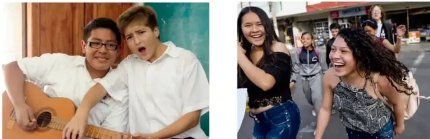 Dos jóvenes sonriendo; uno toca una guitarra ukulele.
