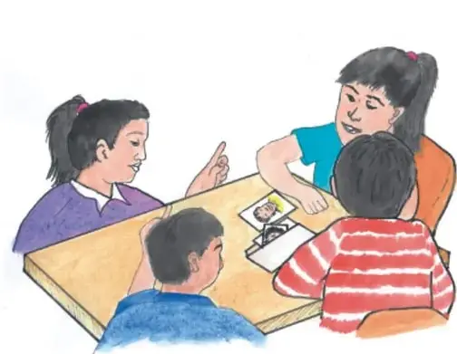 Ilustración de una niña con coletas y un grupo de niños sentados alrededor de una mesa, conversando y revisando tarjetas; una niña levanta el dedo para hablar. Crédito: Dámazo Martínez Hilario, GUERRERO.