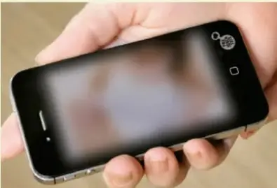 Mano sosteniendo un teléfono inteligente con la pantalla difuminada, junto al recuadro de Sexting.