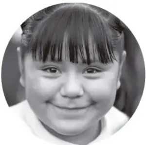 Fotografía en blanco y negro de una niña sonriente con flequillo.