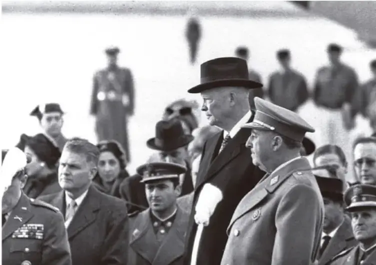 Fotografía en blanco y negro de Francisco Franco junto a militares y civiles, probablemente en un acto oficial.