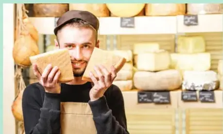 Fotografía de un vendedor sonriente atendiendo a un cliente en un mostrador.