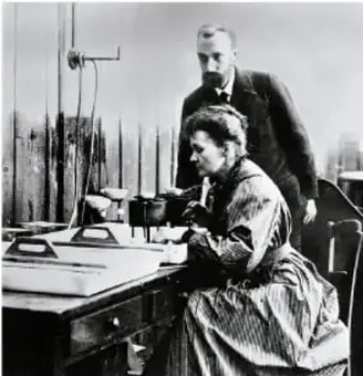 Fotografía en blanco y negro de Marie Curie y Pierre Curie en su laboratorio.