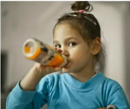 Niña comiendo ensalada con un tenedor, con bocados grandes.
