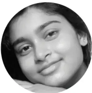 Fotografía en blanco y negro del rostro sonriente de una niña, mirando a la cámara.