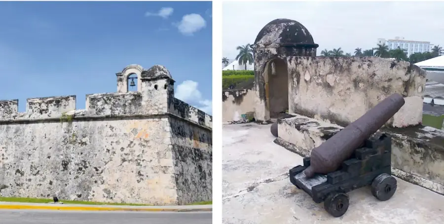 Fotografía de un baluarte de la muralla de Campeche, con muros de piedra, almenas, un espigón con campana y mirador.