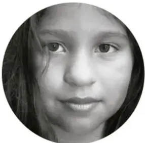 Fotografía circular en blanco y negro del rostro de una niña mirando de frente.