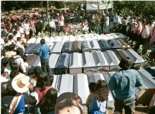 Fotografía de una comunidad indígena reunida alrededor de ataúdes, posiblemente en Acteal.
