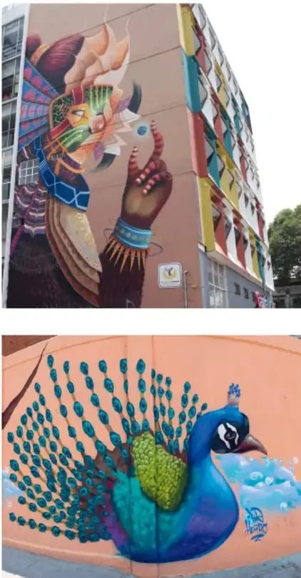 Mural urbano en una esquina de edificio que representa una figura humana con indumentaria y un objeto multicolor de gran formato.