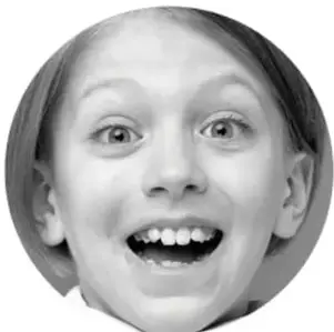 Fotografía de una niña sonriente con los ojos muy abiertos.
