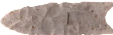 Fotografía de una punta de proyectil tipo Clovis, alargada, de piedra clara, con acanaladura central en la base.
