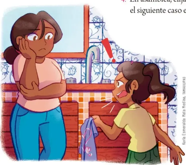 En un baño con azulejos azules, una mujer de cabello castaño recogido, blusa rosa y pantalón azul, escucha con gesto de preocupación y mano en el rostro a una niña de playera amarilla que, molesta, levanta la voz y sostiene una prenda de ropa con un corazón; sobre la niña se dibuja un signo de exclamación rojo. Crédito: Karla Esmeralda Mata Medina, TAMAULIPAS.