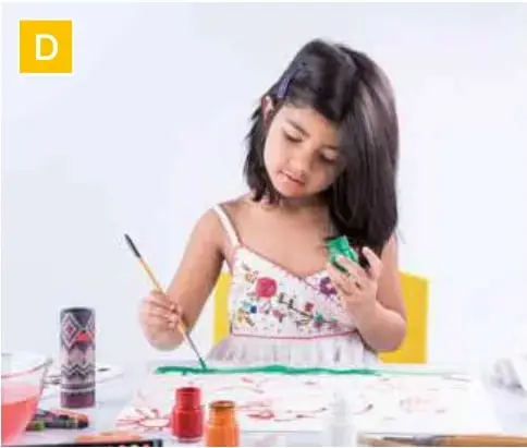 Niña pintando un dibujo con témperas y pincel.