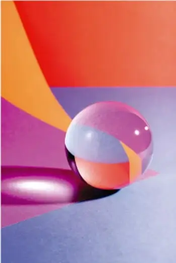 Fotografía de una esfera multicolor con superficie brillante y reflejos, apoyada sobre un plano con luces de colores (naranja, rosa y azul), ilustrando la belleza de la forma esférica.