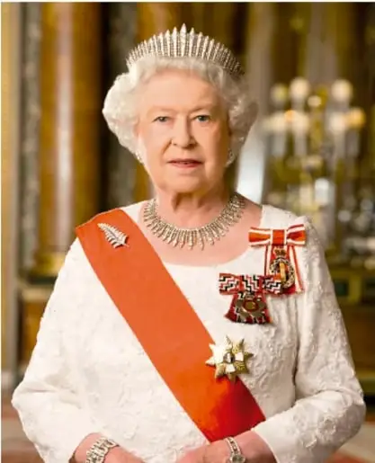 Retrato oficial de la reina Isabel II del Reino Unido con diadema, collar y banda conmemorativa naranja, posando ante un interior palaciego con candelabros.